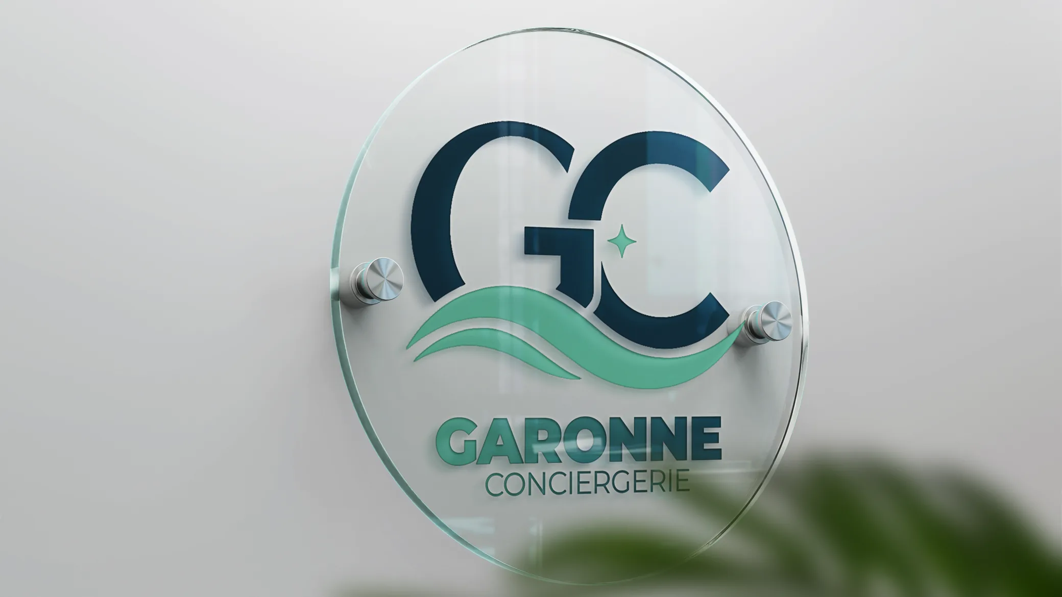 Plaque de signalétique en verre gravée au logo Garonne Conciergerie, posée sur un mur clair